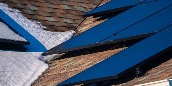 Close Up Detail Of Solar Photovoltaic Panels On Roof With Snow