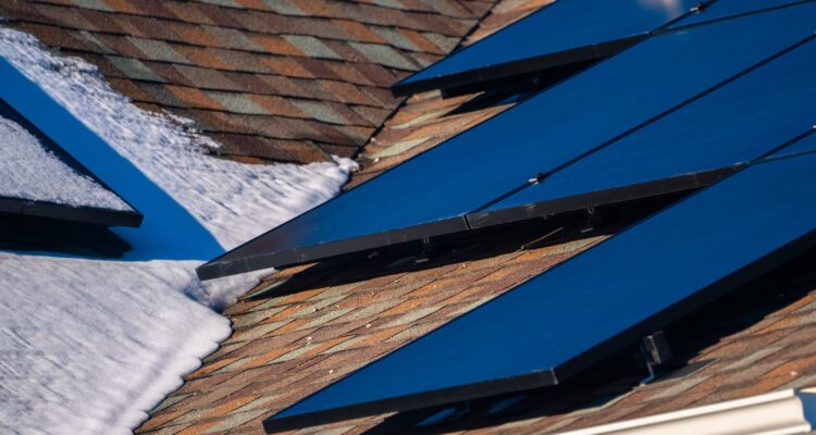 Close Up Detail Of Solar Photovoltaic Panels On Roof With Snow